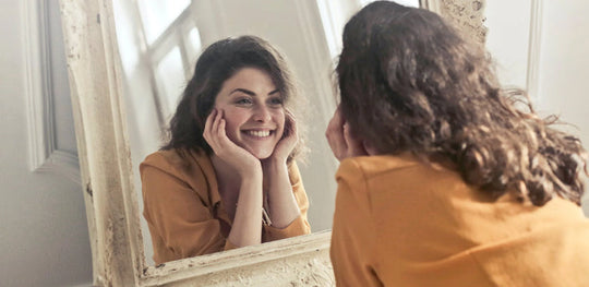 Woman smiling in the mirror after lip flip treatment in Calgary
