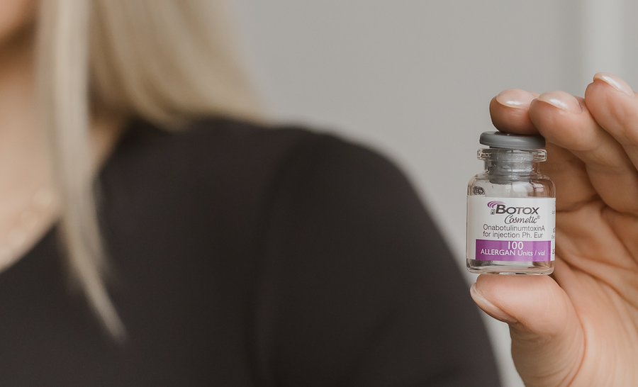 woman holding vial of botox
